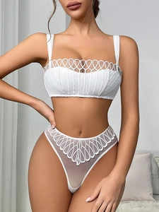 Dettaglio del set intimo bianco con reggiseno in pizzo e perizoma in rete con ricami fini