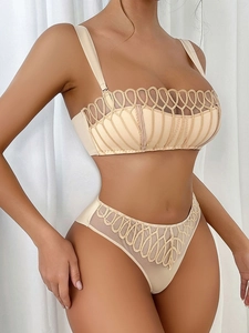 Dettaglio del set di lingerie francese beige con ricami raffinati e finiture in mesh