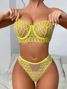 Detail of neon yellow embroidered mesh bra and matching high-cut panty set on model