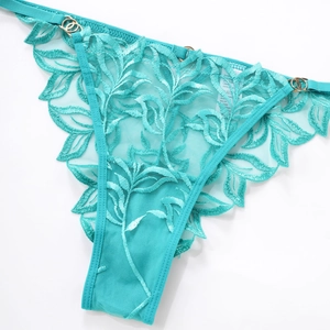 Detail of teal lace thong with intricate leaf embroidery and golden metal ring hardware