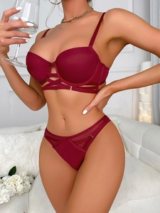 Détail d'un ensemble de lingerie bordeaux avec laçage évidé et empiècements en résille