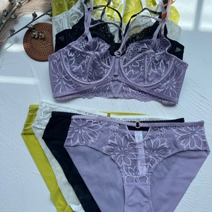 Detailed flat lay of lace lingerie sets with floral embroidery and metal ring details