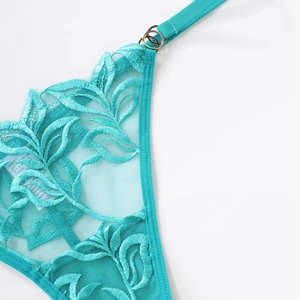 Detailed close-up of blue lace floral embroidery and metal ring buckle with mesh fabric