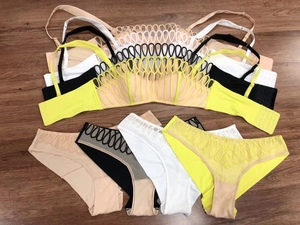 Dettaglio del ricamo in pizzo francese su completi di lingerie velati in quattro colori