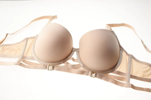 Détail d'un soutien-gorge push-up nude avec brides cage et boucles en métal doré