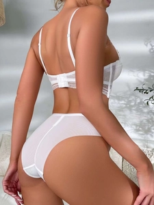 Detailed back view of white lace lingerie set featuring sheer mesh and intricate floral patterns