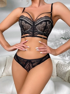 Close-up of black floral lace bra set with strappy hollow details and gold metal rings