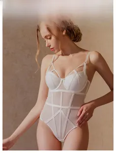 Détail d'un body blanc en tulle avec des bretelles croisées et un tissu transparent