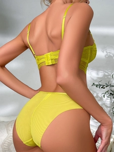 Detailed back view of lime green lace bra and mesh panties on model with natural lighting