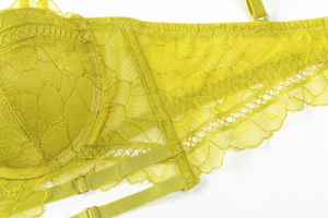 Close-up of bright yellow floral lace texture and adjustable strap with gold metal buckle