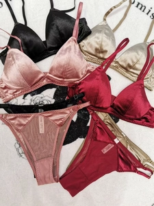 Detail view of colorful velvet satin bralette sets showing scalloped edges and fine texture