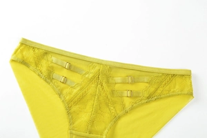 Detailed macro view of yellow floral lace and sheer mesh panties with golden metal rings