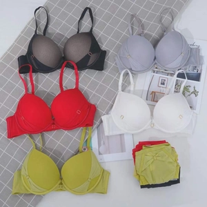 Flat lay of colorful mesh lingerie sets featuring pleated cups and metal ring details