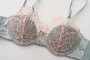 Close-up of floral lace embroidery and satin texture on underwire bra in light grey blue