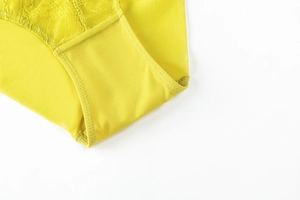 Detail of bright yellow floral lace and breathable mesh fabric on women's underwear