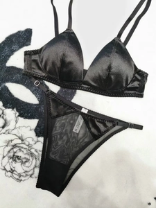 Detail view of black satin and mesh lingerie set with triangle cups and thin straps
