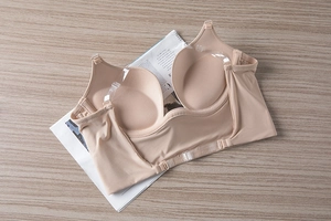 Macro view of nude seamless push-up bra with transparent straps on wooden background