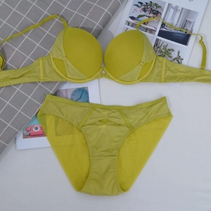Detailed view of neon yellow lace lingerie set with mesh panels and gold ring detail