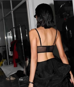 Dettaglio della schiena del reggiseno a corsetto in rete nera con chiusura a gancio regolabile