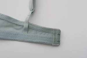 Detail of light blue lace bra featuring mesh fabric, elastic band and double hook-and-eye closure