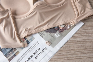 Detail of skin-tone seamless bra with wavy edges and adjustable transparent straps