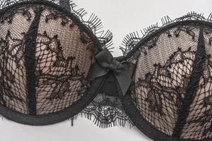 Detail of black eyelash lace bra with fine texture and decorative center bow