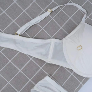 Detailed view of white mesh lingerie set with gold metal rings and adjustable straps