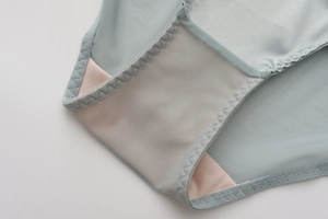 Detail of light blue mesh fabric underwear showing pink cotton crotch and reinforced stitching