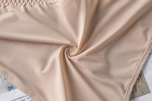 Close-up of seamless skin-tone bra fabric with fine double-needle stitching details