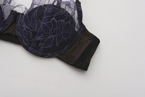 Gros plan d'un soutien-gorge en dentelle violet foncé avec broderies et côtés en satin