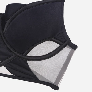 Dettaglio del tessuto liscio e della rete traspirante sul reggiseno nero con ferretto
