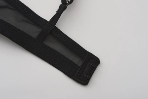 Detail showing the breathable mesh side wings and dual hook-and-eye closure of black bra