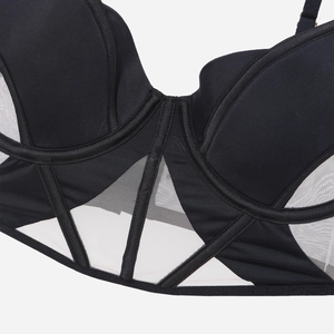 Vista macro dell'elegante reggiseno a bustino nero con inserti in rete e stecche