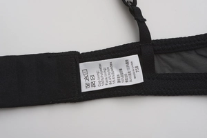 Detail view of black eyelash lace bra wing and shoulder strap with mesh fabric