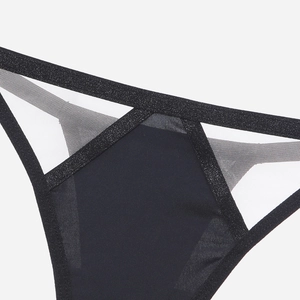 Macro view of seamless thong featuring black fabric with sheer mesh and glitter trim