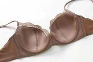 Detailed macro view of dark coffee lace bra with underwire support and mesh side wings