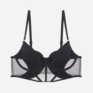 Dettaglio degli inserti in rete nera e fibbie in metallo dorato sul reggiseno