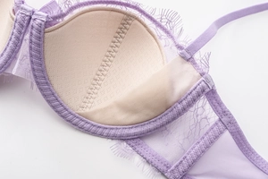 Macro detail of breathable padded bra cups with delicate lavender eyelash lace trim