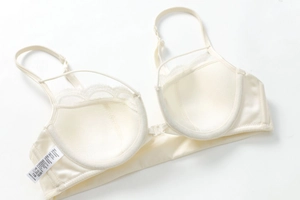 Detailed inner view of beige French lace bra showing 100% cotton lining and quality stitching