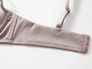 Detail view of pink seamless bra with adjustable straps and reinforced side wings
