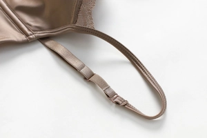 Close-up of adjustable satin straps with delicate lace trim on champagne lingerie
