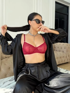 Détail d'un soutien-gorge en dentelle florale rouge foncé avec de fines bretelles