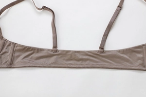 Detail view of coffee-colored bra showing adjustable straps and smooth silk-like fabric