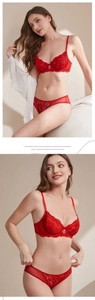 Close-up of red lace lingerie set with pearl detail and elegant floral embroidery