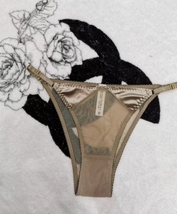 Detail view of champagne satin T-back thong with mesh panels and adjustable straps