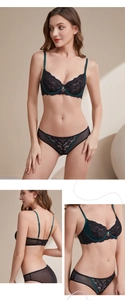 Detail of black floral lace bra set with dark green satin trim and sheer mesh fabric