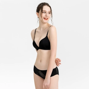 Detail of black seamless V-neck bra and mesh panel briefs on model with ivory background