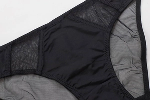 Detail of black mesh paneling and decorative zigzag stitching on seamless lingerie