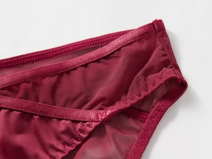 Vue macro du tissu en maille rouge vin et satin avec coutures de précision sur lingerie