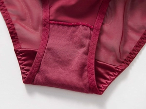 Gros plan détaillé sur une culotte rouge vin en tulle avec tissu respirant et bords ondulés